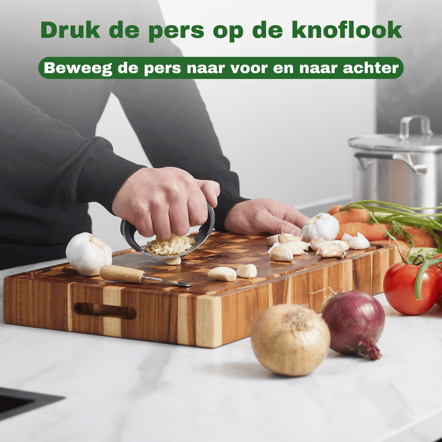 Knoflookpers roestvrij staal in gebruik: knoflook persen op een hakblok