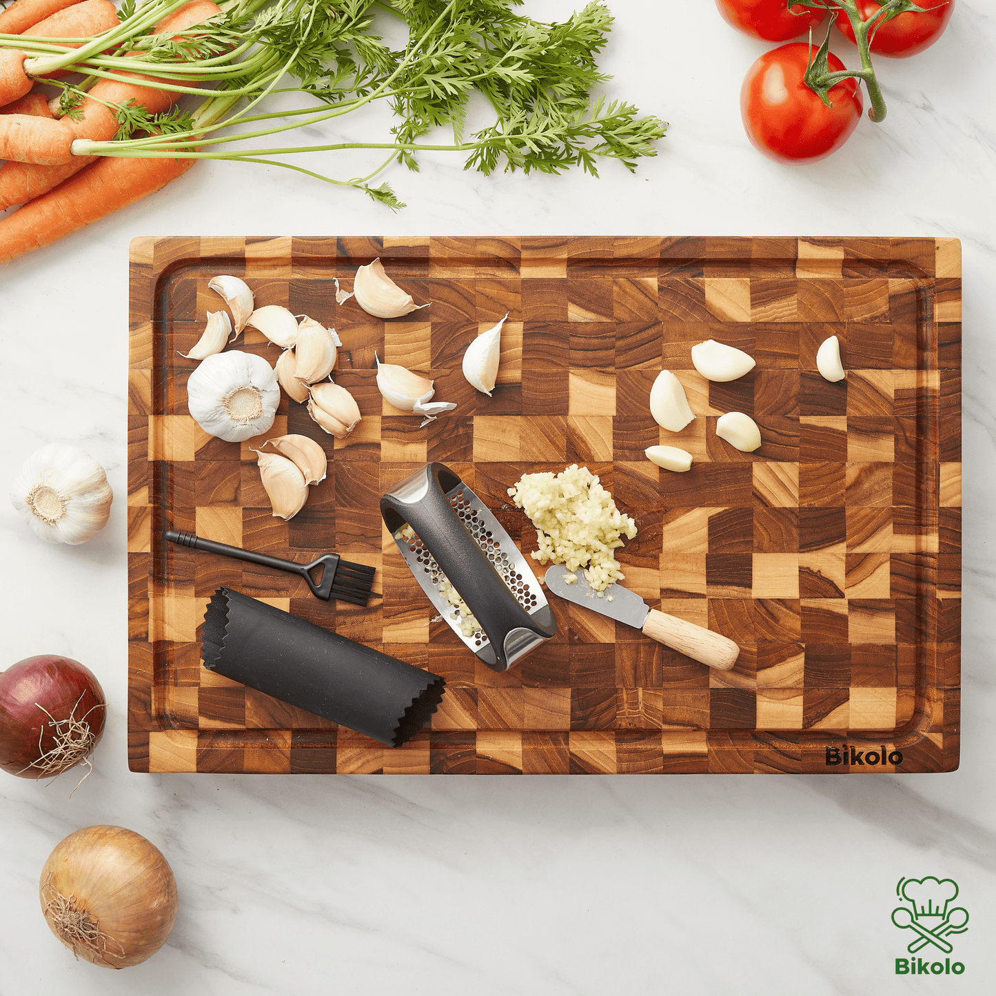 Bikolo knoflookpers met accessoires op houten snijplank in de keuken
