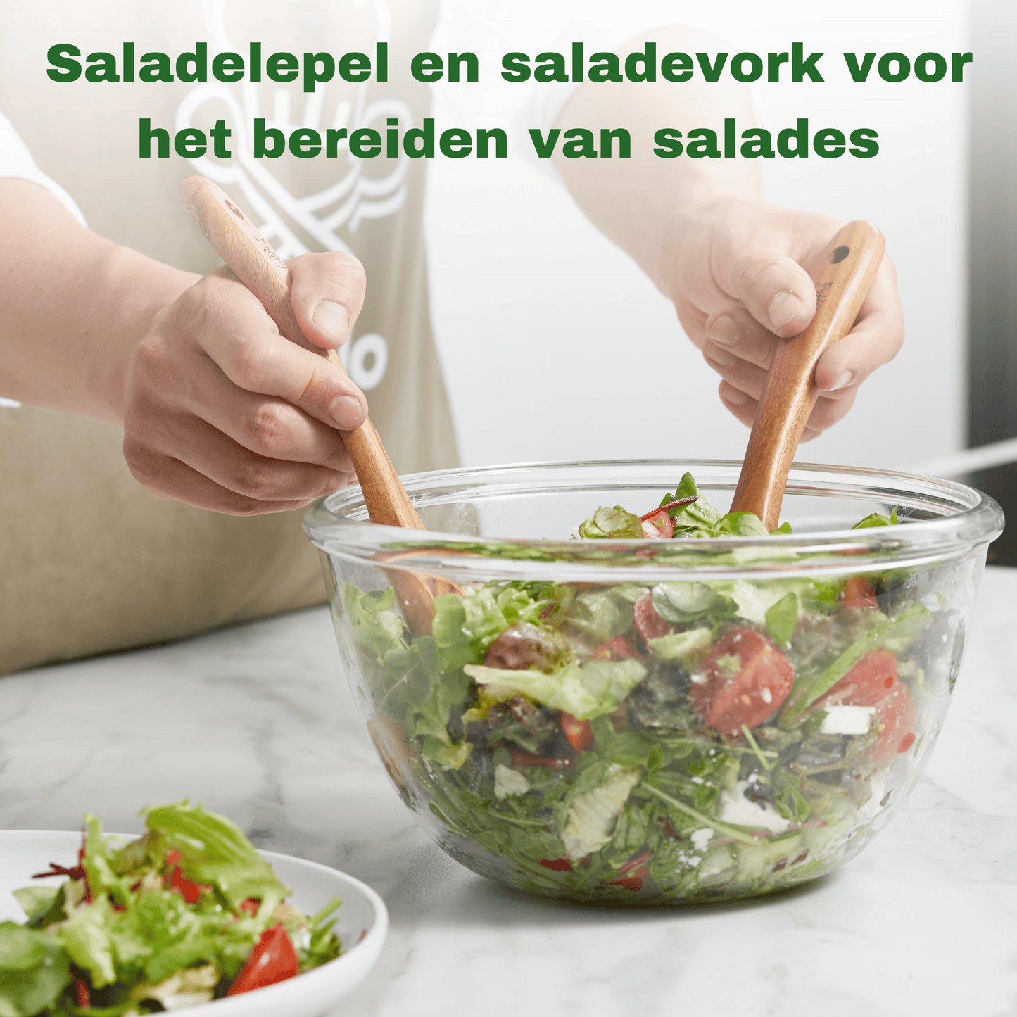 Saladebestek van teak in een saladekom